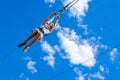 Zipline. A view of a child sliding on a steel cable against a beautiful blue sky with clouds. Extreme and active rest.