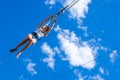 Zipline. A view of a man sliding on a steel cable against a beautiful blue sky. Extreme and active rest.