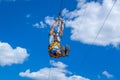 Zipline. A view of a man sliding on a steel cable against a beautiful blue sky. Extreme and active rest.