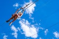 Zipline. A view of a man sliding on a steel cable against a beautiful blue sky. Extreme and active rest.