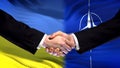 Ukraine and NATO handshake, international friendship relations, flag background