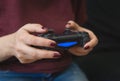 Ukraine, Odessa - July 2, 2019: A girl plays a video game on a playstation 4 joystick. The ps4 gamepad is in the girlÃ¢â¬â¢s hands. Royalty Free Stock Photo