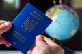 Ukraine, passporton the background of the globe. Ukrainian passports in hands are on the world map. Travel concept Royalty Free Stock Photo