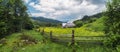 Ukraine rural countryside panorama. Wooden fence and house on Carpathian meadow Royalty Free Stock Photo