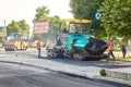 Ukraine, Shostka - June 14, 2019: A group of workers near the grader at the site of laying a new asphalt road