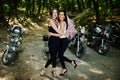 Ukraine, Tarnopol - September 8, 2018: Two young girls at hen party on choppers and wear black leather dress. Biker Woman on