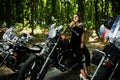 Ukraine, Tarnopol - September 8, 2018: Young woman on chopper and wear black leather dress. Biker Woman on motorcycle