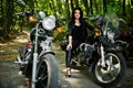 Ukraine, Tarnopol - September 8, 2018: Young woman on chopper and wear black leather dress. Biker Woman on motorcycle