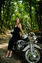 Ukraine, Tarnopol - September 8, 2018: Young woman on chopper and wear black leather dress. Biker Woman on motorcycle