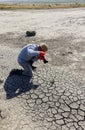 a man with a camera on the dried cracked silt on the bank of the Tiligul estuary, Ukraine
