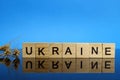 Ukraine word made of wooden letters and wheat ears on a mirror surface