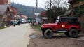 Ukraine, Yaremche - November 20, 2019: a red Jeep Wrangler 4.0i V6 SUV is parked on a rural road near a house in a small town of