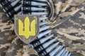 Ukrainian army symbol on machine gun belt lies on ukrainian pixeled military camouflage