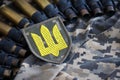 Ukrainian army symbol on machine gun belt lies on ukrainian pixeled military camouflage