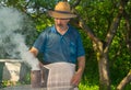 Ukrainian bee-keeper with fuming smoker