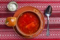 Ukrainian beetroot soup - borscht with sour cream served in a ceramic bowl over traditional red table cloth background Royalty Free Stock Photo