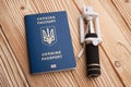 Ukrainian biometric passport with selfi stick on wooden background