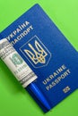 Ukrainian biometric passport with a hundred dollar bill and a pen