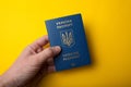 Ukrainian biometric passport id in hand on yellow background