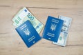 Ukrainian biometric passports id to travel the Europe with dollars and euros money on the table. Inscription in Ukrainian