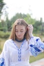 ukrainian blonde girl in national blue dress - embroidered shirt. young woman patriot. outdoors photo of charming female