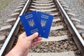 Ukrainian blue biometric passport with identification chip on against rail road background.