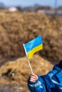 Ukrainian boy holds the flag of Ukraine in his hands. Children`s patriotism. Anxiety and anticipation.