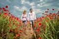 Ukrainian couple go through poppies field Royalty Free Stock Photo