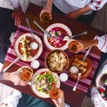 Ukrainian family in traditional closes has a dinner. Ukrainian culture. Family eating and clang glasses together.