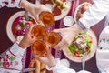 Ukrainian family in traditional closes has a dinner. Ukrainian culture. Family eating and clang glasses together.