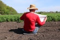 Ukrainian farmer sits near his field and reads a newspaper.