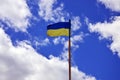 Ukrainian flag against the blue sky with clouds. The official flag of the Ukrainian state includes yellow and blue color Royalty Free Stock Photo