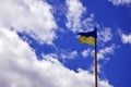 Ukrainian flag against the blue sky with clouds. The official flag of the Ukrainian state includes yellow and blue color Royalty Free Stock Photo