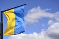 Ukrainian flag on flagpole against the blue cloudless sky. The official flag of the Ukrainian state includes yellow and blue color Royalty Free Stock Photo