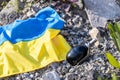 Ukrainian flag and a grenade lying among rubble and ruins, Concept of aggression and war in Ukraine Royalty Free Stock Photo