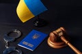 Ukrainian flag and handcuffs on black background, concept of crime and justice in the country Royalty Free Stock Photo