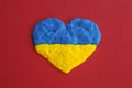 Ukrainian flag. Heart shape of blue and yellow plasticine modeling clay on red maroon texture background. Plasticine finger Royalty Free Stock Photo