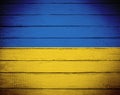 Ukrainian flag painted. Wrinkled blue and yellow colored timber planks. Grungy background with copy space