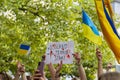 Ukrainian flags and hands holding sign that says Russia is a terrorist state