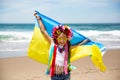 Ukrainian girl carries blue and yellow flag of Ukraine fluttering on the blue sky background Royalty Free Stock Photo