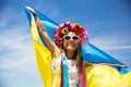 Ukrainian girl carries blue and yellow flag of Ukraine fluttering on the blue sky background Royalty Free Stock Photo