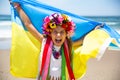 Ukrainian girl carries blue and yellow flag of Ukraine fluttering on the blue sky background Royalty Free Stock Photo