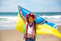 Ukrainian girl carries blue and yellow flag of Ukraine fluttering on the blue sky background Royalty Free Stock Photo