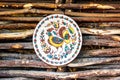 Ukrainian handmade earthenware utensil. Painted plate on wooden wall. Souvenirs From Ukraine in ethnic style.