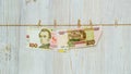 Ukrainian hryvnia and Russian rubles suspended on clothespins. Money laundering, currency fraud and corruption concept