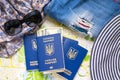 Ukrainian international passport with cash, tatter jeans, hat, on map background. Preparing luggage for traveling Royalty Free Stock Photo