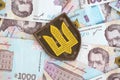 Ukrainian military symbol and hryvnia bills. Payments to soldiers of the Ukrainian army, salaries to the military