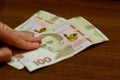 Ukrainian money hryvnias on the table with hand. Problem of cash and bribe in politics. Financial problem in post soviet countries