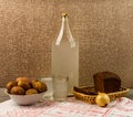 Ukrainian national drink and snack. The big bottle and glass of moonshine on the old wooden table. Russian vodka and snack.