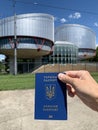 Ukrainian passport against the background of the building of the European Court of Human Rights. Strasbourg, France Royalty Free Stock Photo